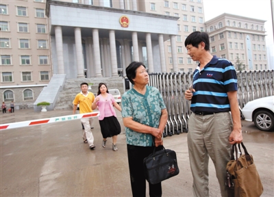 7月9日，聂树斌母亲和律师刘博今在办理第二天庭审的旁听证。新京报记者 王贵彬 摄