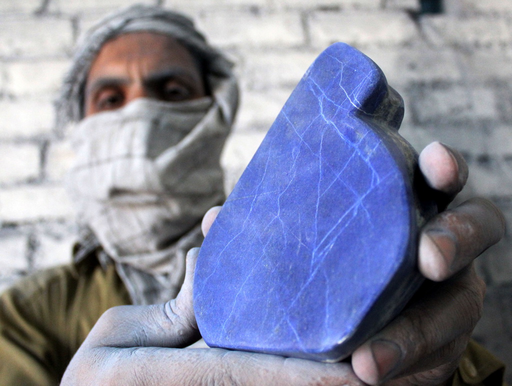 4月17日，在巴基斯坦西北部城市白沙瓦，一名工人展示抛光过后的青金石。  新华社发（穆罕默德·哈迪摄）