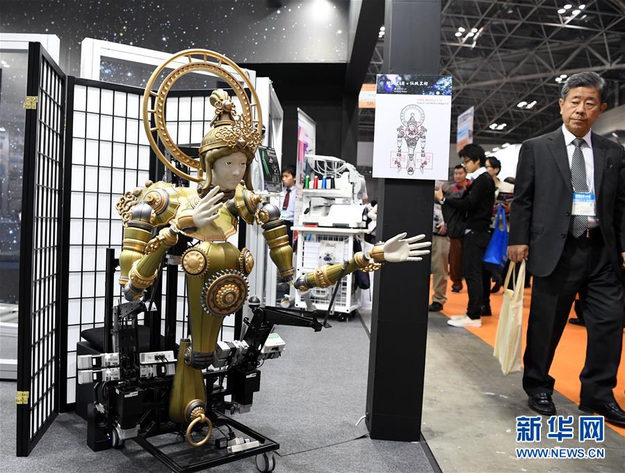 11月29日，在日本东京，人们在2017国际机器人展上观看机器人表演。