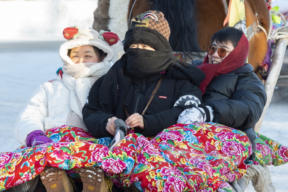1月13日，游客在北极村乘坐马拉爬犁游玩。