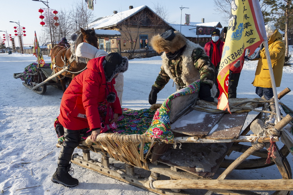  1月13日，游客乘坐马拉爬犁在北极村游玩。